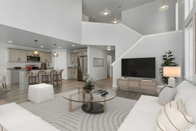 4273 W Watchmen Way, Herriman, UT 84096 - living area featuring light wood-style flooring, a high ceiling, and recessed lighting