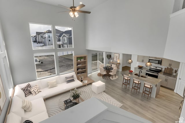 4273 W Watchmen Way, Herriman, UT 84096 - living room with light wood-type flooring, a towering ceiling, and ceiling fan