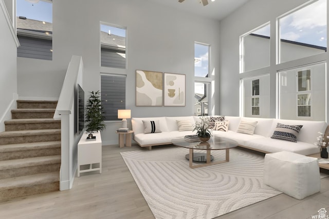 4273 W Watchmen Way, Herriman, UT 84096 - living area featuring stairway, a high ceiling, a ceiling fan, and light wood-style floors