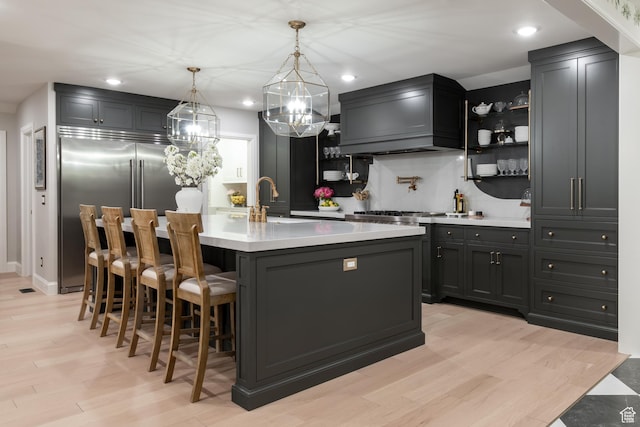 4605 S Ledgemont Dr E, Salt Lake City, UT 84124 - kitchen with stainless steel built in fridge, light countertops, open shelves, light wood finished floors, and backsplash