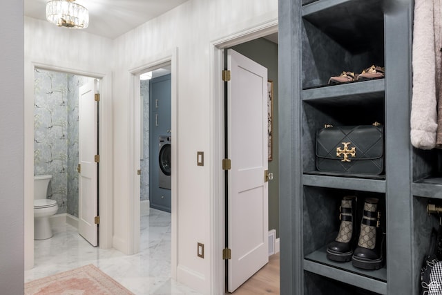 4605 S Ledgemont Dr E, Salt Lake City, UT 84124 - hall with washer / clothes dryer, a chandelier, and marble finish flooring