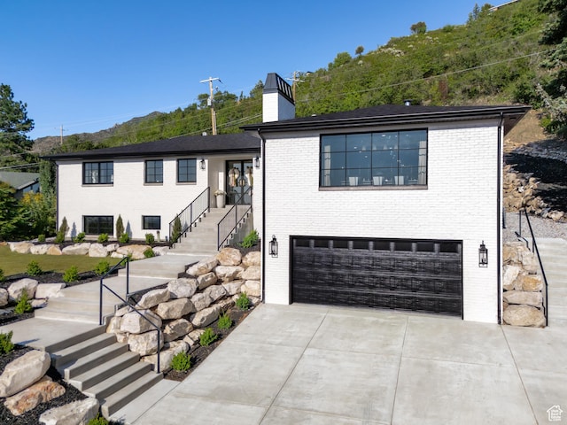 4605 S Ledgemont Dr E, Salt Lake City, UT 84124 - view of front of property with stairs, a garage, concrete driveway, a chimney, and brick siding