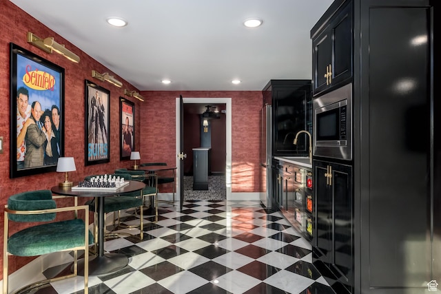 4605 S Ledgemont Dr E, Salt Lake City, UT 84124 - kitchen with stainless steel microwave, recessed lighting, dark cabinets, light countertops, and dark flooring