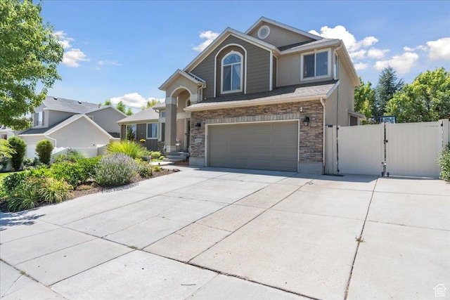 5719 W Boulder Creek Rd, West Jordan, UT 84081 - view of front of home with a gate, concrete driveway, a garage, and stone siding
