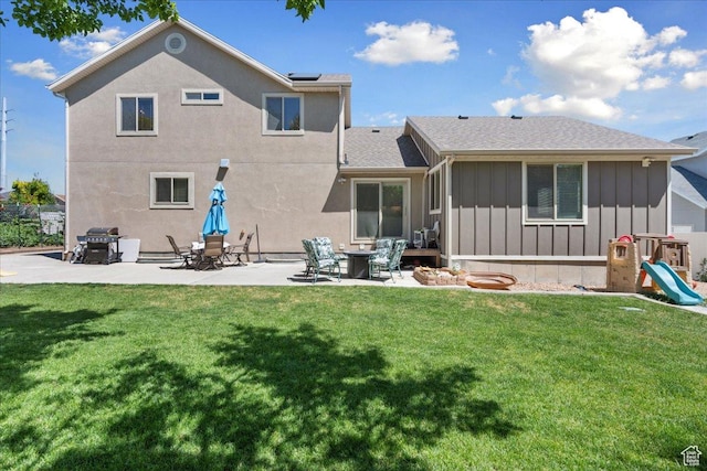 5719 W Boulder Creek Rd, West Jordan, UT 84081 - back of house featuring board and batten siding, a patio, and a lawn