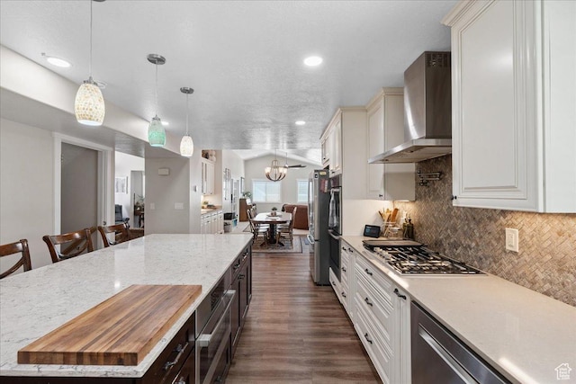 5719 W Boulder Creek Rd, West Jordan, UT 84081 - kitchen with wall chimney exhaust hood, appliances with stainless steel finishes, a center island, tasteful backsplash, and a chandelier
