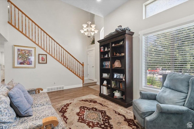 5719 W Boulder Creek Rd, West Jordan, UT 84081 - living area featuring a towering ceiling, a chandelier, stairs, and wood finished floors