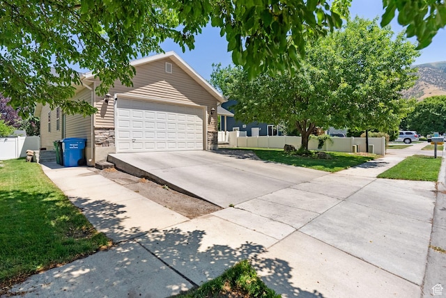 151 E 360 N, Providence, UT 84332 - view of front of house with driveway, an attached garage, stone siding, and a mountain view