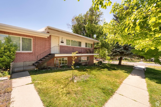 906 E Third Ave, Salt Lake City, UT 84103 - view of front of house with brick siding, a front yard, and stairway
