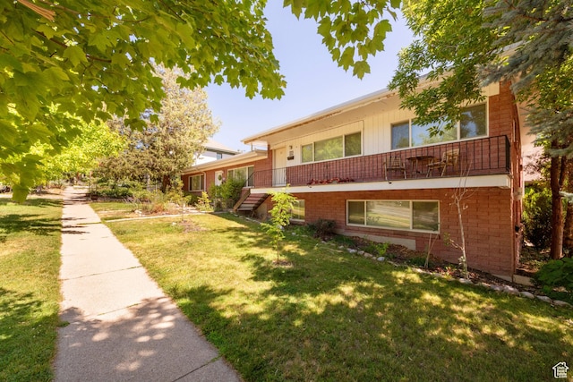 906 E Third Ave, Salt Lake City, UT 84103 - view of front facade featuring brick siding, a front yard, and a balcony