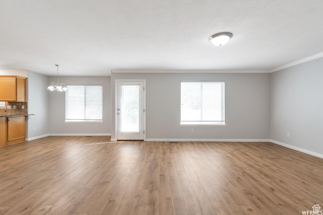 901 S Apple Grove Ln, Pleasant Grove, UT 84062 - unfurnished living room featuring a chandelier, light wood-type flooring, and ornamental molding