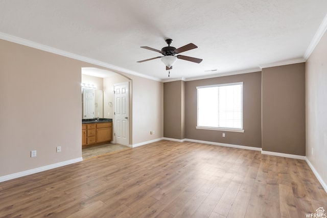 901 S Apple Grove Ln, Pleasant Grove, UT 84062 - unfurnished bedroom featuring light wood-type flooring, crown molding, arched walkways, connected bathroom, and ceiling fan