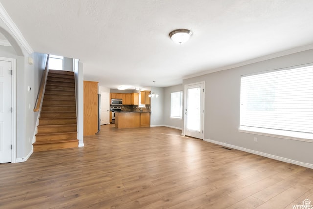 901 S Apple Grove Ln, Pleasant Grove, UT 84062 - unfurnished living room featuring crown molding, stairway, light wood-type flooring, a chandelier, and arched walkways