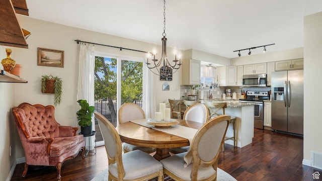 3737 S Washington Dr W, Magna, UT 84044 - dining area featuring a chandelier, dark wood-style floors, and track lighting
