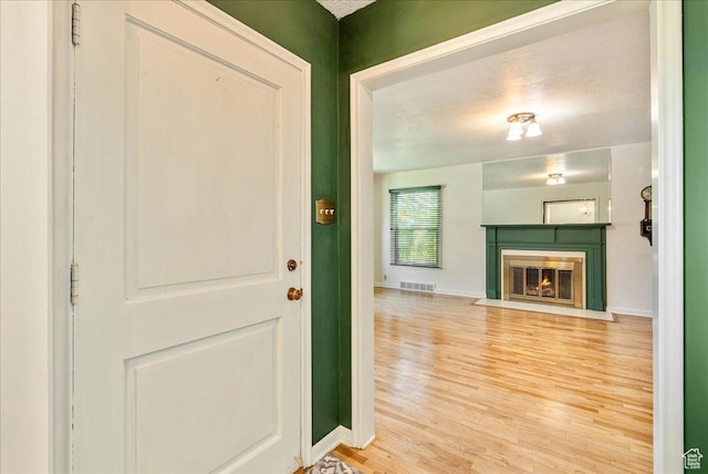 458 E 8800 S, Sandy, UT 84070 - foyer with light wood-style flooring, a fireplace with flush hearth, and a textured ceiling