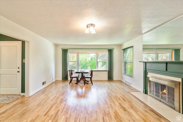 458 E 8800 S, Sandy, UT 84070 - dining space featuring wood finished floors, a fireplace with flush hearth, and a textured ceiling
