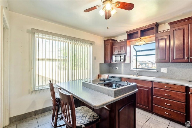 458 E 8800 S, Sandy, UT 84070 - kitchen with stainless steel appliances, light tile patterned flooring, a kitchen bar, a ceiling fan, and a kitchen island