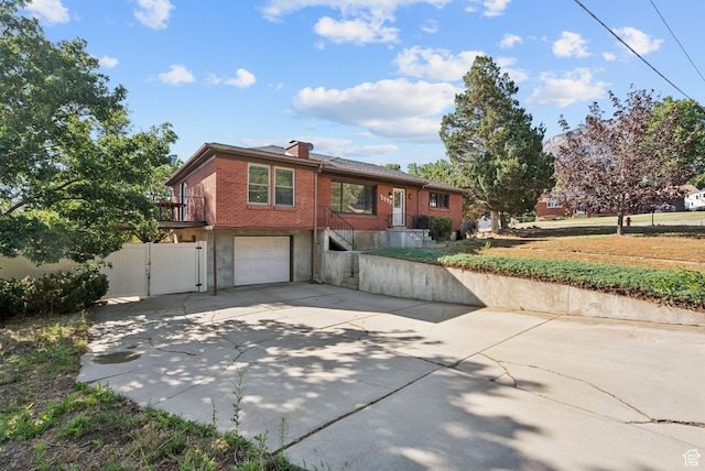 2999 N 300 E, North Ogden, UT 84414 - view of front of house with a garage, a gate, concrete driveway, brick siding, and a chimney