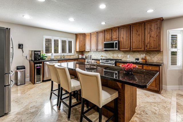 2148 E Pinecrest Ln S, Sandy, UT 84092 - kitchen with appliances with stainless steel finishes, beverage cooler, backsplash, a kitchen breakfast bar, and recessed lighting