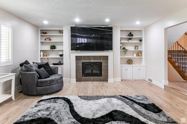 2148 E Pinecrest Ln S, Sandy, UT 84092 - living area with wood finished floors, stairs, a tile fireplace, recessed lighting, and built in features