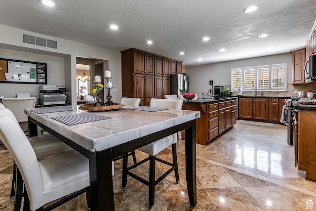 2148 E Pinecrest Ln S, Sandy, UT 84092 - kitchen with a kitchen island, stainless steel appliances, recessed lighting, a textured ceiling, and a chandelier