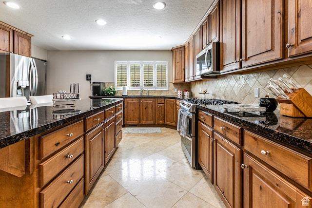 2148 E Pinecrest Ln S, Sandy, UT 84092 - kitchen featuring appliances with stainless steel finishes, decorative backsplash, brown cabinetry, dark stone countertops, and recessed lighting