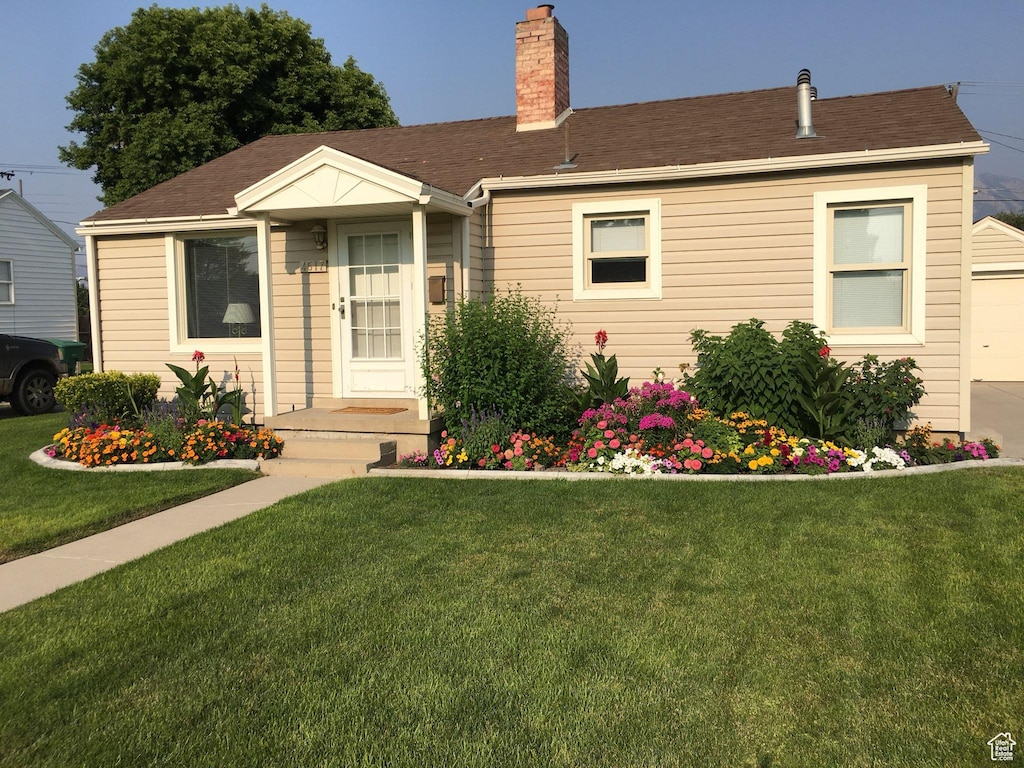 4617 S Box Elder W, Murray, UT 84107 - view of front facade with a front yard, a chimney, and a garage