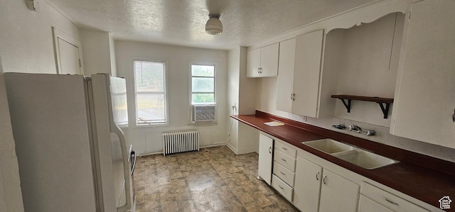 40 W 400 N Unit 1-6, Spanish Fork, UT 84660 - kitchen featuring radiator, freestanding refrigerator, a textured ceiling, and white cabinetry