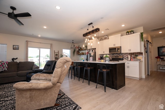 365 N 800 E, Beaver, UT 84713 - kitchen with appliances with stainless steel finishes, open floor plan, a breakfast bar area, light countertops, and white cabinets