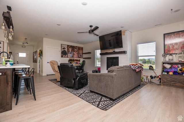 365 N 800 E, Beaver, UT 84713 - living area featuring light wood-style floors, a ceiling fan, a large fireplace, and healthy amount of natural light