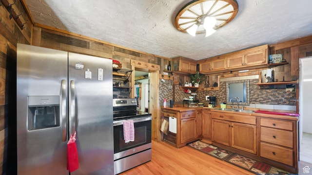 180 N State St, Sigurd, UT 84657 - kitchen featuring stainless steel appliances, open shelves, light wood-style floors, brown cabinets, and a textured ceiling