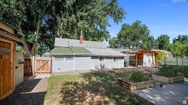 180 N State St, Sigurd, UT 84657 - back of house with a garden, a gate, a chimney, and a fenced backyard