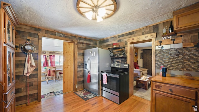 180 N State St, Sigurd, UT 84657 - kitchen with stainless steel appliances, light wood-style floors, a textured ceiling, and brown cabinetry