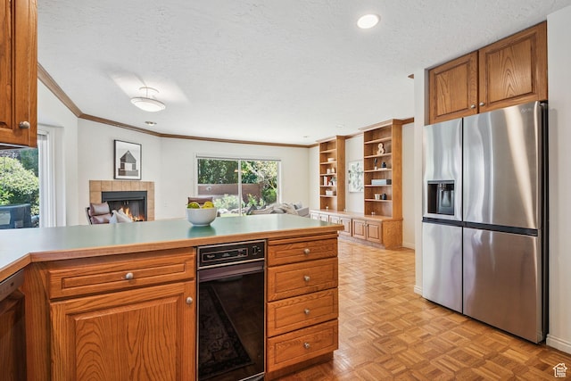 2056 E Sierra View Cir, Millcreek, UT 84109 - kitchen featuring appliances with stainless steel finishes, a textured ceiling, a tile fireplace, brown cabinets, and ornamental molding