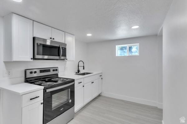 9593 S 700 E, Sandy, UT 84070 - kitchen with appliances with stainless steel finishes, light countertops, light wood-style flooring, white cabinets, and recessed lighting