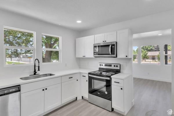 9593 S 700 E, Sandy, UT 84070 - kitchen with stainless steel appliances, light wood-style flooring, light countertops, white cabinets, and recessed lighting