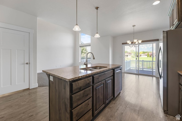 947 S 2040 W, Orem, UT 84059 - kitchen with appliances with stainless steel finishes, wood finished floors, dark brown cabinetry, a center island with sink, and a chandelier
