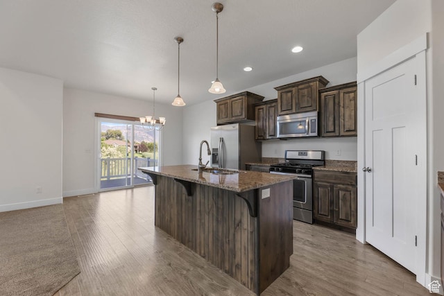 947 S 2040 W, Orem, UT 84059 - kitchen with stainless steel appliances, a breakfast bar area, light wood-style flooring, a center island with sink, and recessed lighting