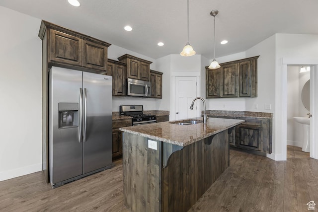 947 S 2040 W, Orem, UT 84059 - kitchen featuring stainless steel appliances, dark wood finished floors, dark brown cabinets, stone countertops, and a kitchen bar
