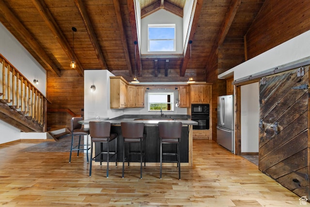 16 N Porcupine Ln, La Sal, UT 84530 - kitchen featuring black appliances, a wood ceiling with exposed beams, a peninsula, light wood-type flooring, and a breakfast bar area