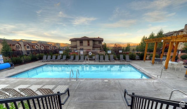 5541 N Slalom Way, Park City, UT 84098 - pool at dusk featuring a community pool, a patio area, and a pergola