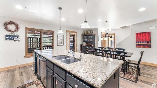 5541 N Slalom Way, Park City, UT 84098 - kitchen featuring stainless steel dishwasher, light wood-style floors, a kitchen island with sink, healthy amount of natural light, and recessed lighting