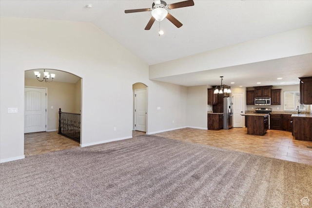 5464 S 3200 W, Roy, UT 84067 - unfurnished living room with a chandelier, light carpet, arched walkways, high vaulted ceiling, and recessed lighting
