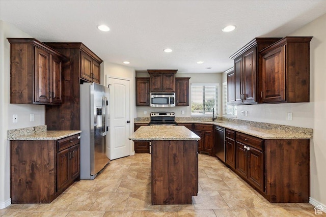 5464 S 3200 W, Roy, UT 84067 - kitchen featuring appliances with stainless steel finishes, a center island, dark brown cabinetry, recessed lighting, and light stone countertops