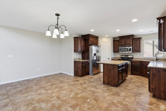 5464 S 3200 W, Roy, UT 84067 - kitchen with stainless steel appliances, a kitchen island, dark brown cabinetry, recessed lighting, and a chandelier