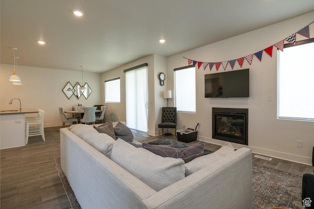 2049 N Harvest Village Ln, Saratoga Springs, UT 84045 - living area featuring dark wood-type flooring, a glass covered fireplace, and recessed lighting