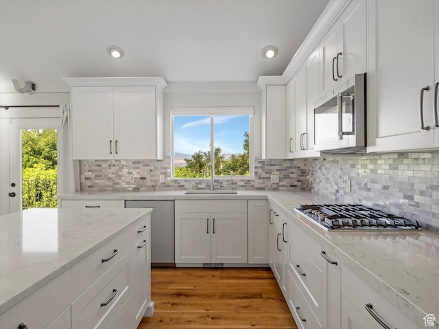 2960 E Oak Park Ln S, Holladay, UT 84117 - kitchen with appliances with stainless steel finishes, white cabinets, recessed lighting, decorative backsplash, and light stone counters