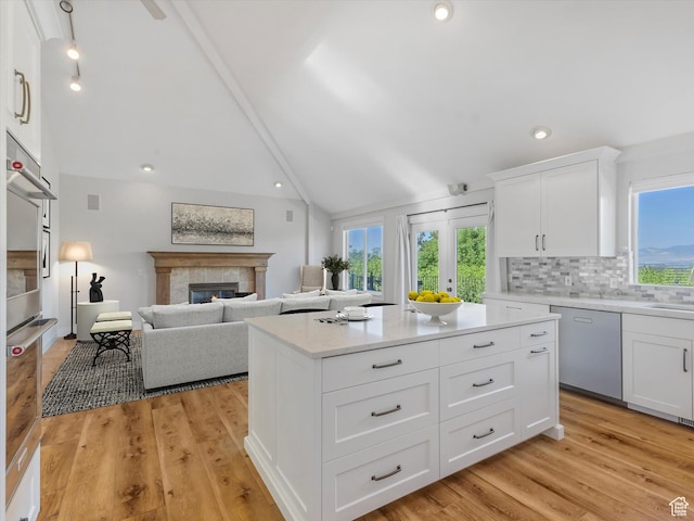 2960 E Oak Park Ln S, Holladay, UT 84117 - kitchen featuring appliances with stainless steel finishes, a tile fireplace, lofted ceiling, light wood-style floors, and white cabinetry