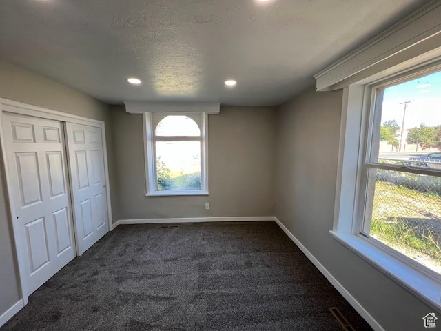 9173 S 1300 W, West Jordan, UT 84088 - unfurnished bedroom with dark carpet, multiple windows, a closet, recessed lighting, and a textured ceiling