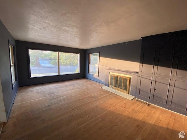 41 N 300 E, Richfield, UT 84701 - unfurnished living room with hardwood / wood-style floors, plenty of natural light, and a glass covered fireplace